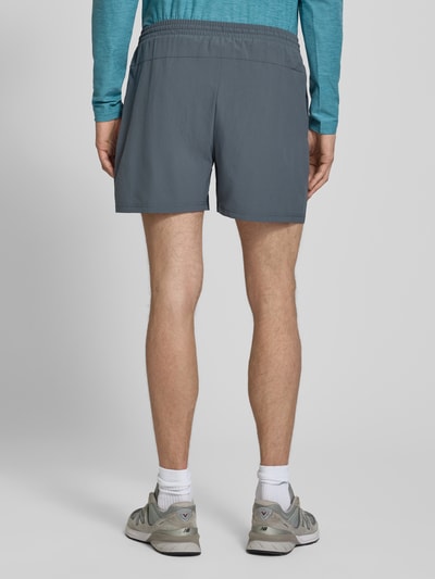 Männermodel trägt Shorts mit elastischem Bund und Logo von New Balance, Regular-Fit, Tunnelzug, Grau, Ganzkörperansicht Rückansicht.