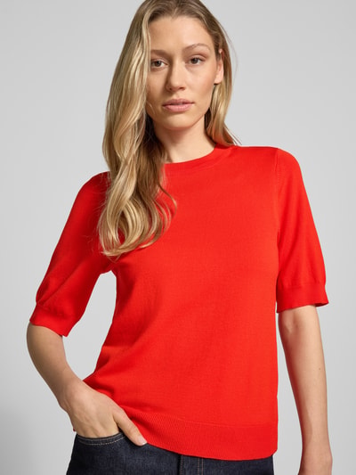 Frauenmodel trägt Strickshirt aus Viskose-Mix mit Rundhalsausschnitt Modell 'LENA' von YAS, körpernaher Schnitt, 1/2-Arm, gerippte Abschlüsse, leuchtend rote Farbe, glatte Textur, Nahaufnahme Oberkörper.