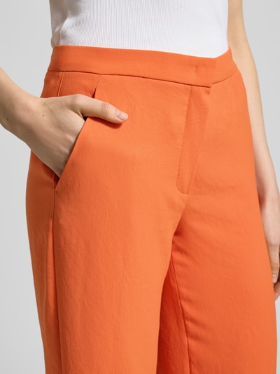 Vrouwenmodel draagt feloranje Hose mit Eingrifftaschen Modell 'PALINA 6/8' van Raffaello Rossi, verkorte fit, detailopname heup en zak.
