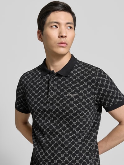 Männermodel trägt Slim Fit Poloshirt mit Logo-Muster Modell 'Paigam' von JOOP! Collection, Baumwoll-Elasthan-Mix, Nahaufnahme Oberkörper.