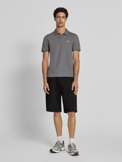 Männermodel trägt Sweatshorts mit Logo-Print von REVIEW aus schwarzem Material-Mix mit Baumwoll-Anteil, Loose-Fit, elastischer Bund, Bundweite 45 cm, Innenbeinlänge 28 cm, Ganzkörperansicht von vorne.