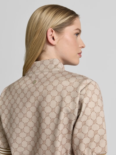 Frauenmodel trägt sukienka knielanges Kleid mit stójka model 'Toina' von JOOP!, mieszanka bawełny, prosty krój, wzór z logo, zamek błyskawiczny, kolor beżowy, faktura gładka, długość do kolan, długość tyłu w rozmiarze 36: 45 cm, szerokość w rozmiarze 36: 41 cm, długość rękawów w rozmiarze 36: 27 cm, detalowe ujęcie z tyłu
