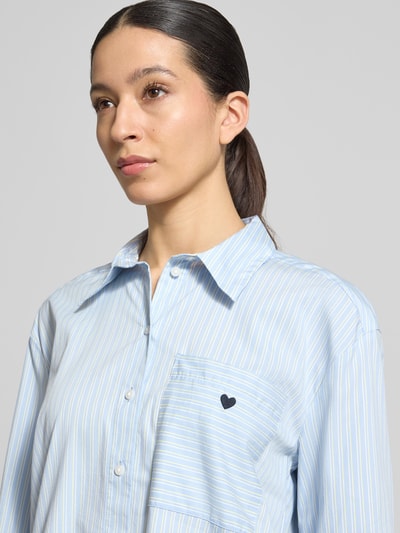 Frauenmodel trägt Loose Fit Hemdbluse aus Baumwoll-Mix von Tom Tailor, mehrfarbig gestreift, Popeline-Textur, Nahaufnahme Oberkörper.