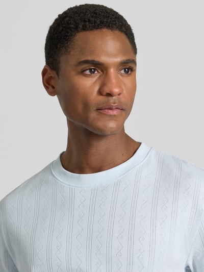 Männermodel trägt T-Shirt in Jaquard-Strick mit Rundhalsausschnitt von Lindbergh, Reine Baumwolle, Regular-Fit, Label-Detail, Nahaufnahme Oberkörper.