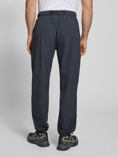 Männermodel trägt Trackpants mit Reißverschlusstaschen Modell 'HALO MOVE' von HALO, Regular Fit, Material-Mix mit Stretch-Anteil, Ganzkörperansicht Rückansicht.