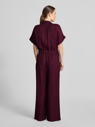 Frauenmodel trägt Jumpsuit aus Viskose-Lyocell-Mix von MORE in Dunkelrot, glatter Stoff, tailliert, Ganzkörperansicht Rückansicht.