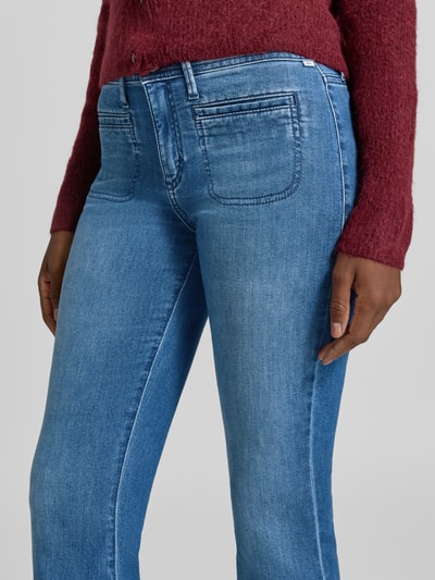 Frauenmodel trägt Bootcut-Jeans aus Baumwoll-Mix Modell 'SHAKIRA' von Brax, blaue Denim-Optik, mittelwasch, Damen Bootcut-Jeans von Brax, Nahaufnahme Oberkörper.
