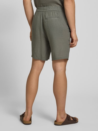 Męski model nosi Regular Fit Shorts aus Leinen-Viskose-Mix Modell 'LAURENCE' von Only & Sons, oliwkowy, krój regular fit, kieszenie boczne i tylna, gładka tekstura, tylny widok pełnej sylwetki.
