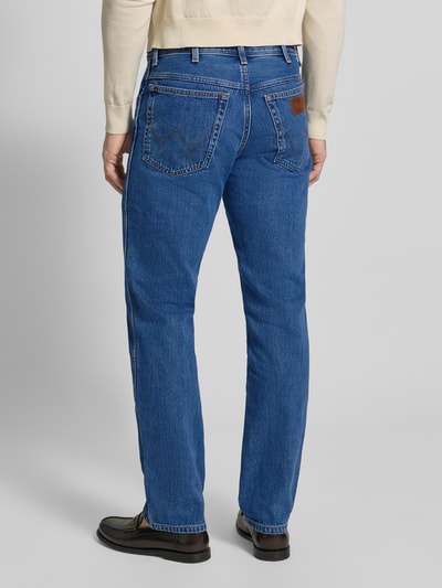 Männermodel trägt Bootcut Jeans mit Label-Detail Modell 'Texas' von Wrangler, blaue Baumwolle, 5-Pocket, Rückansicht Ganzkörperansicht.