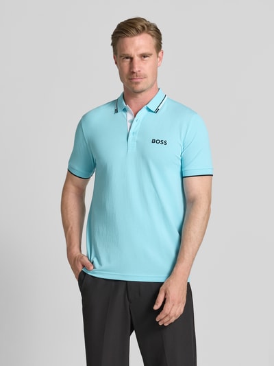 Męski model nosi Regular Fit Poloshirt aus Baumwoll-Mix Modell 'PADDY PRO' von BOSS Green, jasnoniebieska koszulka polo, przód, ujęcie całej sylwetki.