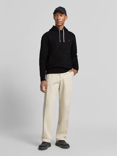 Mannenmodel draagt zwarte regular fit hoodie uit katoenmix van Polo Ralph Lauren, lichte broek, Ganzkörperansicht van voren. Heren hoodie.