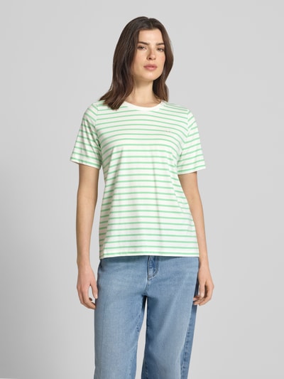 Frauenmodel trägt Regular Fit T-Shirt aus reiner Baumwolle von s.Oliver RED LABEL mit Optik: Unifarben, Muster: Gestreift, Stitching-Applikation, Rundhals, Ärmelform: Kurzarm, Materialverarbeitung: Jersey, Farbe hellgrün und weiß, glatte Textur, Ganzkörperansicht von vorne.