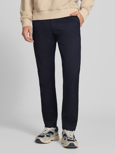Männermodel trägt Skinny Fit Hose aus Baumwoll-Mix Modell 'SID' von Carhartt Work In Progress in Dunkelblau, Ganzkörperansicht von vorne. Baumwoll-Mix mit Stretch-Anteil, Knopf- und Reißverschluss, seitliche Eingrifftaschen und Gesäßtaschen, Bundweite 45 cm, Innenbeinlänge 79 cm.