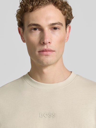 Męski model nosi Relaxed Fit T-Shirt aus reiner Baumwolle Modell 'TEE 10' von BOSS Green, beżowy, gładka faktura, zbliżenie na górną część torsu.
