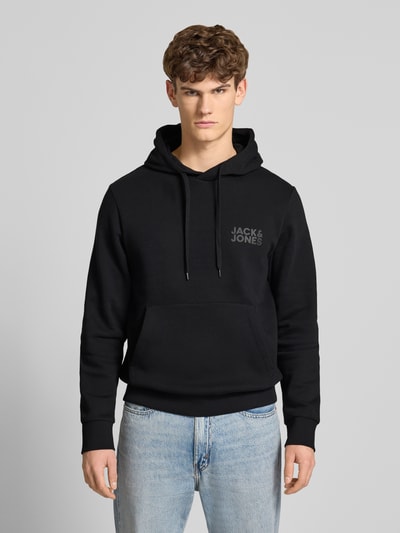 Männermodel trägt Hoodie mit Label-Print und Känguru-Tasche von Jack & Jones, schwarz, Baumwoll-Mix, Regular Fit, Ganzkörperansicht von vorne