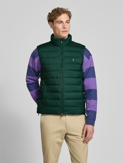 Männermodel trägt Regular Fit Weste mit Logo-Stitching von Polo Ralph Lauren in Dunkelgrün, glatte Struktur, Ganzkörperansicht von vorne. Herren Weste von Polo Ralph Lauren.