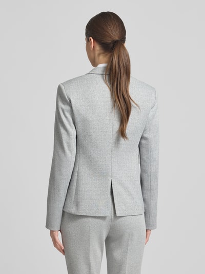 Frauenmodel trägt Shaped Fit Blazer mit Allover-Muster Modell 'JIA13A' von BOSS, Reverskragen, Rückenschlitz, Pattentaschen, Ganzkörperansicht Rückansicht.