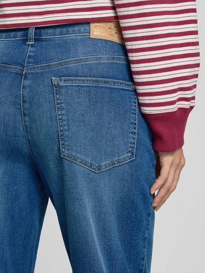 Frauenmodel trägt Relaxed Fit Barrel Jeans aus Baumwoll-Mix Modell 'Bobbie' von MAC in mittlerem Blau mit sichtbarer Gesäßtasche, Damen Barrel Jeans von MAC, Nahaufnahme Rückansicht.
