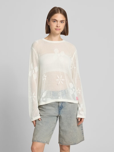 Kobiece model prezentuje sweter z dzianiny z okrągłym dekoltem Model 'Ronja' od OH APRIL, bawełna, krój regular fit, haftowane logo, widok całej sylwetki z przodu.