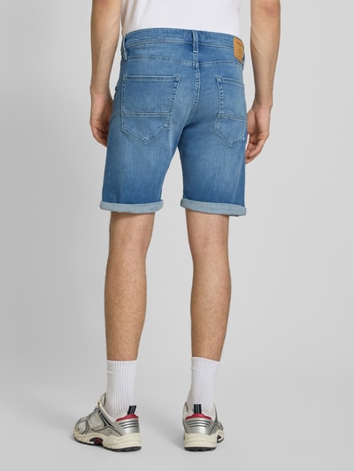 Mężczyzna model nosi Jeansshorts mit Umschlag Modell 'RICK' od Jack & Jones, bawełniany miks ze stretchem, krój regular fit, jasnoniebieski denim, Szerokość w rozmiarze M: 42 cm, długość nogawki wewnętrznej: 23 cm, widok całej sylwetki z tyłu