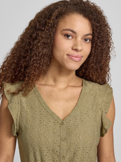 Vrouwenmodel draagt Regular Fit Jumpsuit met ajourwerk model 'LELISA' van Only, look: effen, kapmouwen, V-hals, knoopsluiting, strikceintuur. Nahaufnahme Oberkörper.