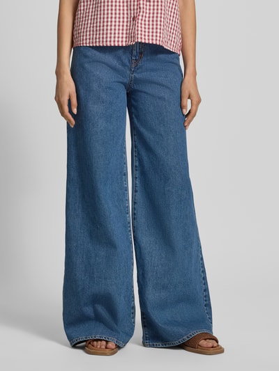 Frauenmodel trägt Wide-Leg-Pants aus blauem Baumwoll-Denim mit Label-Patch, 5-Pocket-Design und Knopf-Reißverschluss, Modell 'SARONG' von Max Mara, Passform Wide-Fit, reine Baumwolle, Denim-Optik, Nahaufnahme Unterkörper.