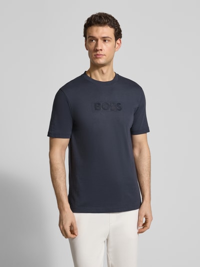 Männermodel trägt Regular Fit T-Shirt aus reiner Baumwolle Modell 'TS_TERRACE' von BOSS Green, unifarben, 3D-Label Print, Nahaufnahme Oberkörper.