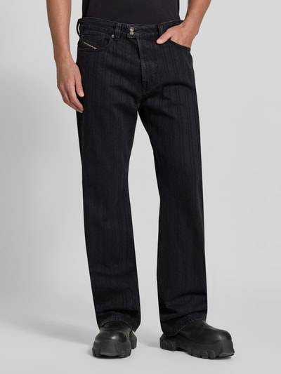 Männermodel trägt Straight Fit Jeans mit Viskose-Anteil von Diesel, Baumwoll-Mix, 5-Pocket, schwarz, Logo-Detail, Nahaufnahme Oberkörper.