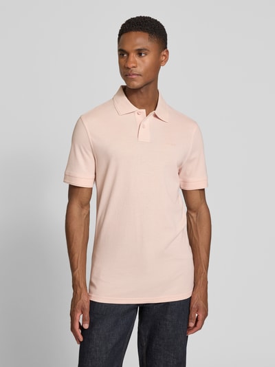 Mannenmodel draagt Regular Fit poloshirt uit puur katoen model 'PRIME' van BOSS Orange, look: effen, piqué, labelapplicatie, lichte textuur, polokraag, V-hals, korte knoopsluiting, korte mouw, materiaalverwerking: piqué, kleur zachtroze, frontale volledige lichaamsopname.