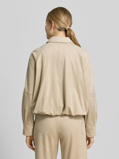 Frauenmodel trägt Jacke mit Knopfleiste und Eingrifftaschen Modell 'Nayomi' von Someday in Beige, strukturierter Material-Mix, Relaxed Fit, Ganzkörperansicht Rückansicht.