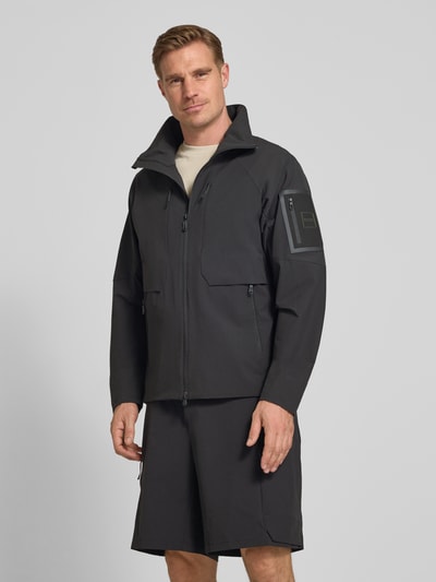 Männermodel trägt Regular Fit Trainingsjacke mit Label Patch Modell 'OW_GLOBE' von BOSS Green, Optik: Unifarben, Schwarz, Ganzkörperansicht von vorne.