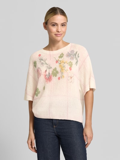Kobiece modelka ma na sobie Relaxed Fit Pullover aus Alpaka-Mix od Marc Cain, mieszanka wełny z alpaki z dodatkiem wełny, imitacja dzianiny, dekolt w serek, rękaw o dł. 1/2, długość tyłu w rozmiarze 36: 53 cm, długość rękawów w rozmiarze 36: 38 cm, przód z kwiatowym nadrukiem w pastelowych kolorach, kremowy odcień, miękka tekstura, prosty krój, całkowity widok z przodu.