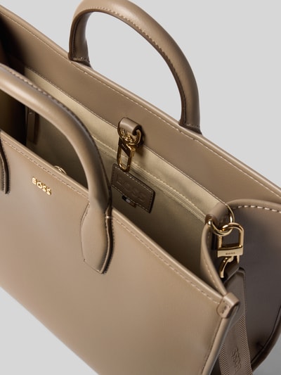 Produktfoto, glatte beige Oberfläche mit goldfarbenen Metallelementen, klare Kanten, Umhängetasche mit Label-Detail Modell 'Sandy MED Tote' von BOSS, Damen Umhängetasche