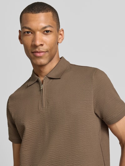Männermodel trägt Regular Fit Poloshirt mit Strukturmuster von MCNEAL in Braun, Baumwoll-Mix, Reißverschluss, Kurzärmelig, Nahaufnahme Oberkörper.