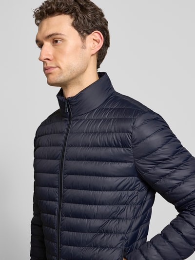 Männermodel trägt Steppjacke mit Stehkragen und Zweiwege-Reißverschluss von Geox in dunkelblau, regular fit, Nahaufnahme Oberkörper