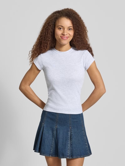 Frauenmodel trägt T-Shirt mit Rundhalsausschnitt Modell 'EVERYDAY' von Topshop in Weiß, Baumwoll-Mix, Slim Fit, schlichte Oberfläche, kombiniert mit Jeansrock, Ganzkörperansicht von vorne.