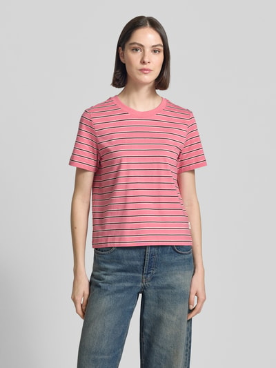 Modelka kobieca ma na sobie Regular Fit T-Shirt aus reiner Baumwolle od s.Oliver RED LABEL, w paski, krój krótki, dżersej, różowy, aplikacja z logo, okrągły dekolt, krótki rękaw, wykonany z czystej bawełny, efekt: wzór w paski na całej powierzchni, widok całej sylwetki z przodu.