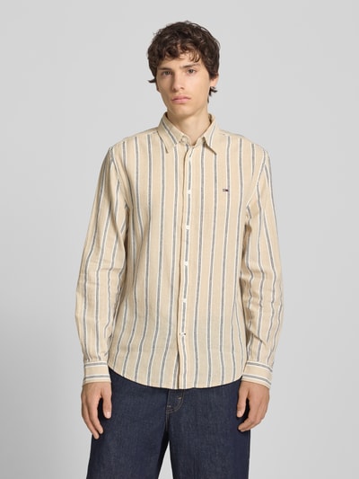 Männermodel trägt Regular Fit Freizeithemd aus Leinen-Baumwoll-Mix von Tommy Jeans, Mehrfarbig, Gestreift, Logo-Schriftzug, Ganzkörperansicht von vorne.
