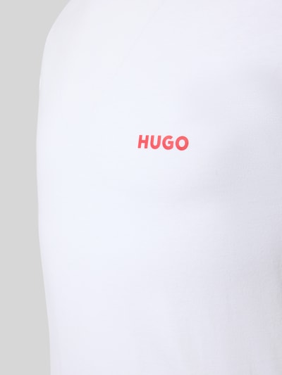Männermodel draagt Regular Fit T-Shirt Set aus reiner Baumwolle im 3er-Pack van HUGO, look: effen, labelprint, ronde hals, korte mouw, puur katoen, nahaufnahme bovenlichaam.