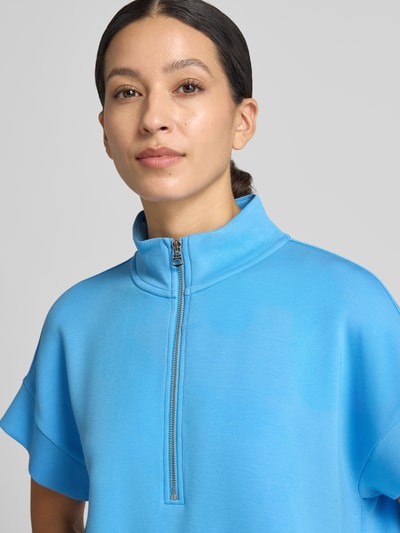 Frauenmodel trägt Sweatshirt mit Troyer-Kragen Modell 'Ritchie' von VARLEY, leuchtend blau, glatte Textur, Nahaufnahme Oberkörper.