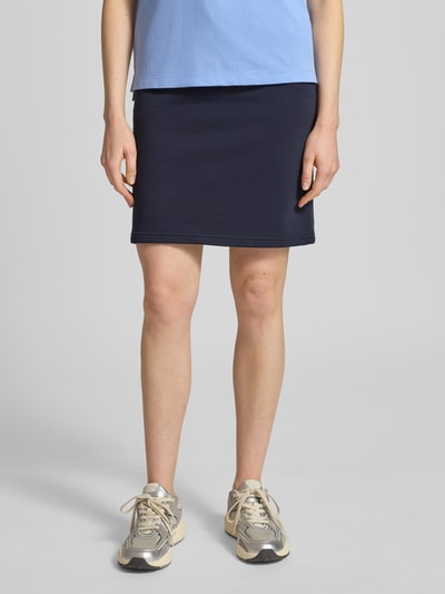 Vrouwenmodel draagt Sweatrock met Label-Stitching van Gant in donkerblauw katoenmix, recht model, minirok, elastische band met tunnelkoord, bandwijdte maat S 37 cm, totale lengte maat S 52 cm, detailopname onderlichaam, vooraanzicht.