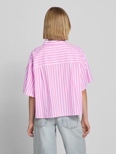 Frauenmodel trägt Cropped Bluse mit Label-Stitching Modell 'VEXTOWN' von American Vintage, gestreift in Rosa und Weiß, reine Baumwolle, Hemdblusenkragen, Knopfleiste, Allover-Look, Rückansicht, Ganzkörperansicht.
