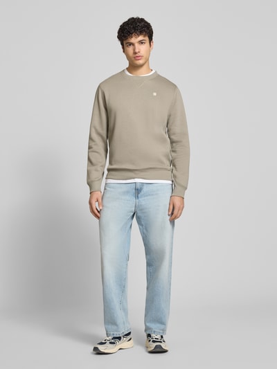 Männermodel trägt Sweatshirt mit Rundhalsausschnitt und Label-Stitching von G-Star Raw in Beige, Baumwoll-Mix, Regular-Fit, Ganzkörperansicht von vorne.