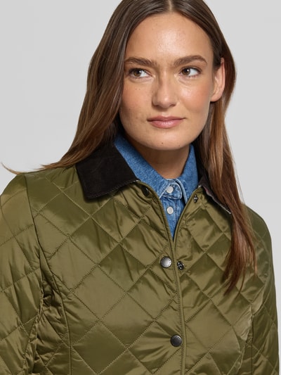 Frauenmodel trägt Shaped Fit Steppjacke mit Cord-Kragen Modell 'DEVERON' von Barbour, olivgrün, Steppmuster, Nahaufnahme Oberkörper.