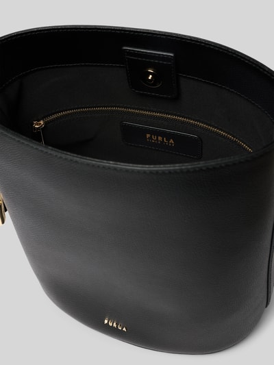 Produktfoto, czarna torebka typu bucket bag z aplikacją z logo, model 'Roxie' od Furla, zapięcie na magnes, główna przegroda, regulowany pasek na ramię, przegródka zapinana na zamek błyskawiczny, szerokość w rozmiarze 1: 24 cm, długość w rozmiarze 1: 26 cm, głębokość w rozmiarze 1: 17 cm, długość paska na ramię w rozmiarze 1: 67 cm