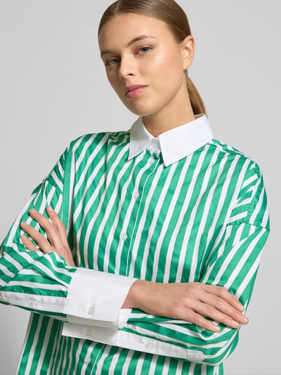 Frauenmodel trägt Regular Fit Hemdbluse mit abgerundetem Saum von Christian Berg Woman, grün-weiß gestreift, Satin, Nahaufnahme Oberkörper.