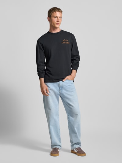 Mannelijk model draagt Regular Fit Longsleeve met Logo-Stitching model 'Engineer' van DEUS EX MACHINA, zwart, puur katoen, ronde hals, elastische mouwboorden, ruglengte maat M 70 cm, volledig lichaam vooraanzicht.