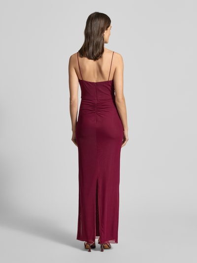 Modelka kobieca nosi Slim Fit Abendkleid mit Gehschlitz od Hey Kyla w kolorze bordowym z siateczką, rozcięciem i podszewką; widok całej sylwetki z tyłu.