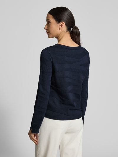 Modelka nosi Regular Fit Pullover aus reiner Baumwolle von Tom Tailor, ciemnogranatowy, faktura w prążki, crew neck, długi rękaw, dzianina, bawełna, u dołu i na rękawach rozcięcia z wywinięciem, widok całej sylwetki z tyłu.