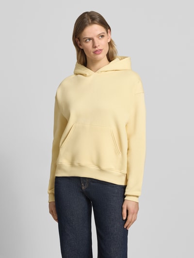 Vrouwenmodel draagt Regular Fit Hoodie met kangoeroezak model 'Iconic' van Gina Tricot in katoenmix, dames, elastische boorden, frontale volledige lichaamsopname.